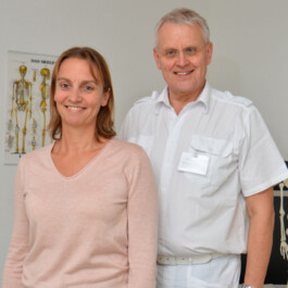 Praxisteam der Orthopädie Höckel - Ärztin und Arzt vor Skelett-Modell in freundlicher Praxisatmosphäre 